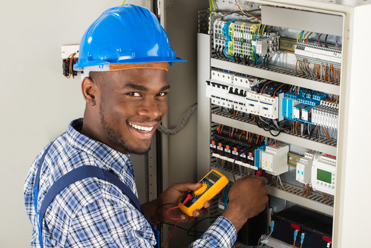 African electrician working on an electrical panel